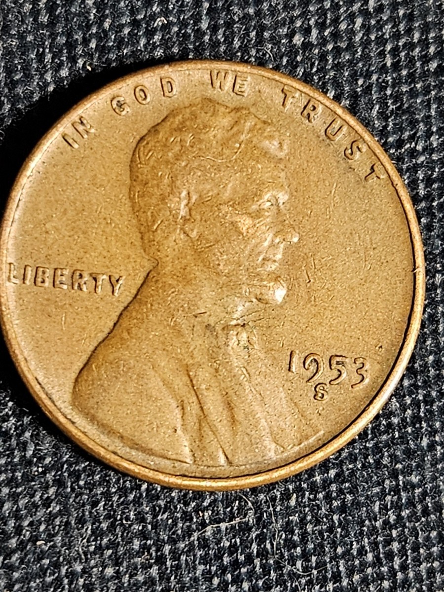 1953 wheat penny off-center strike error showing blank crescent on one side with partial Lincoln portrait and date still visible